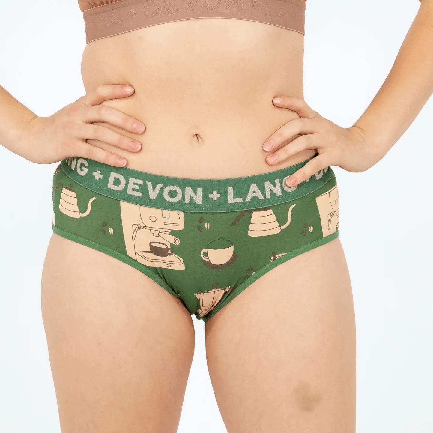 Green underwear with 'Devon + Lang' branding and coffee-themed design on a plain background