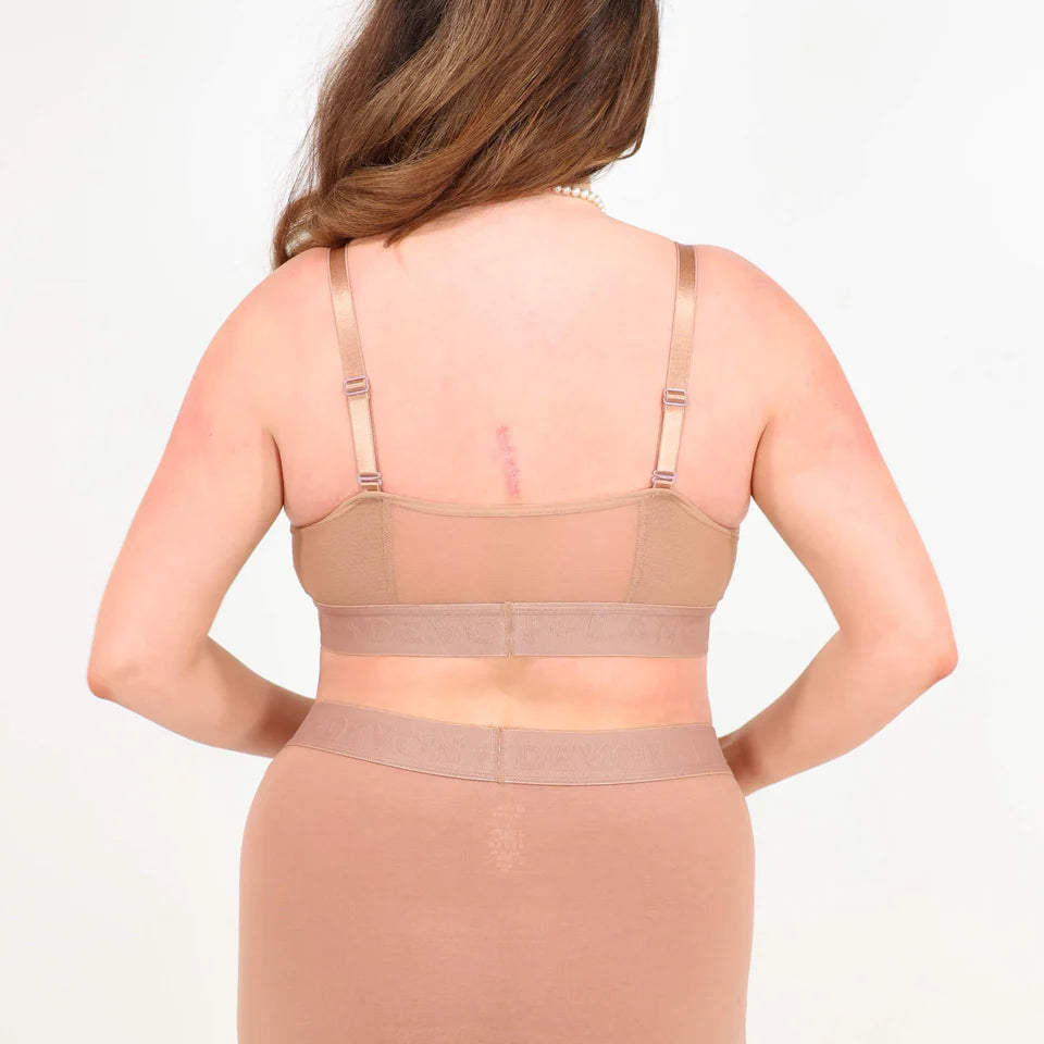 A woman wearing a brown bra and shorts set on a white background