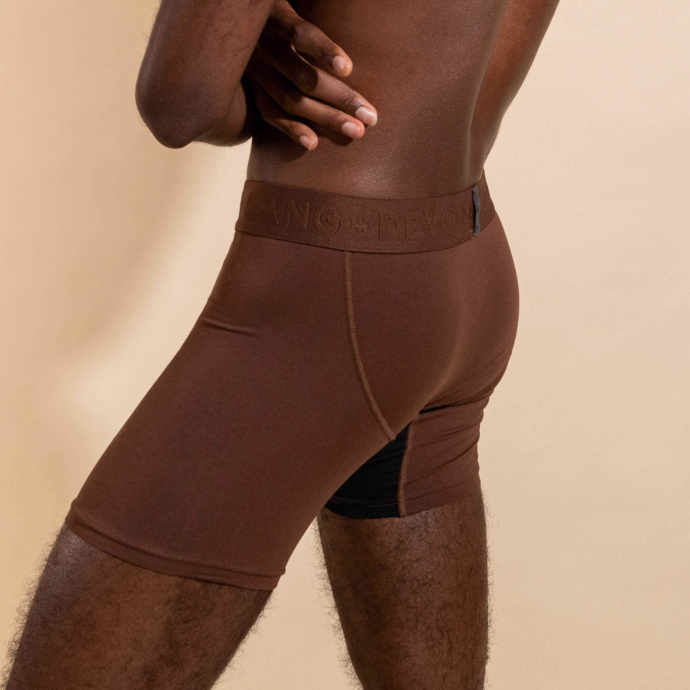 Brown boxer briefs worn by a person on a beige background