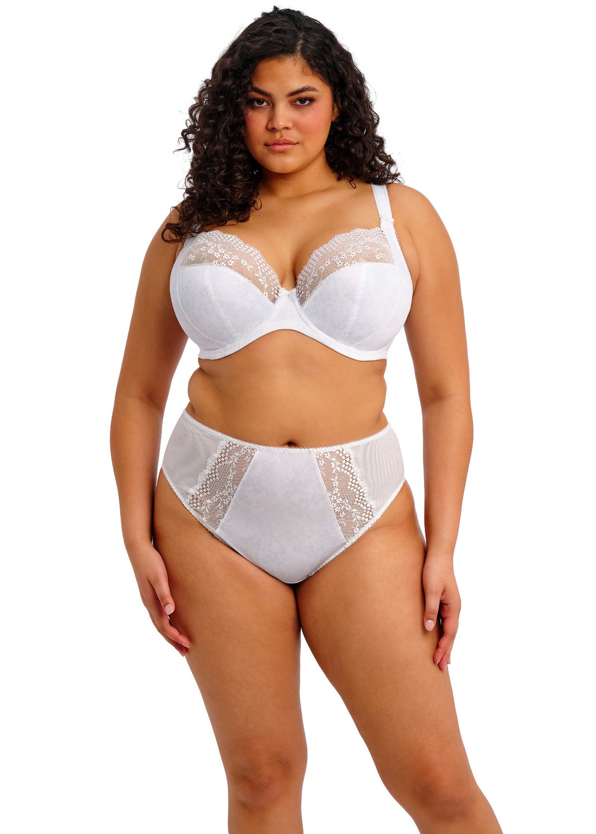 Woman wearing a white lace bra and panties set on a white background