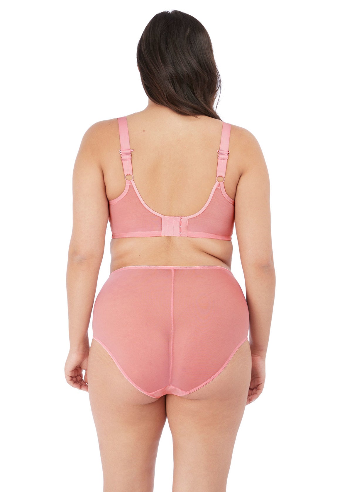 Woman wearing a pink bra and high-waisted underwear set on a white background