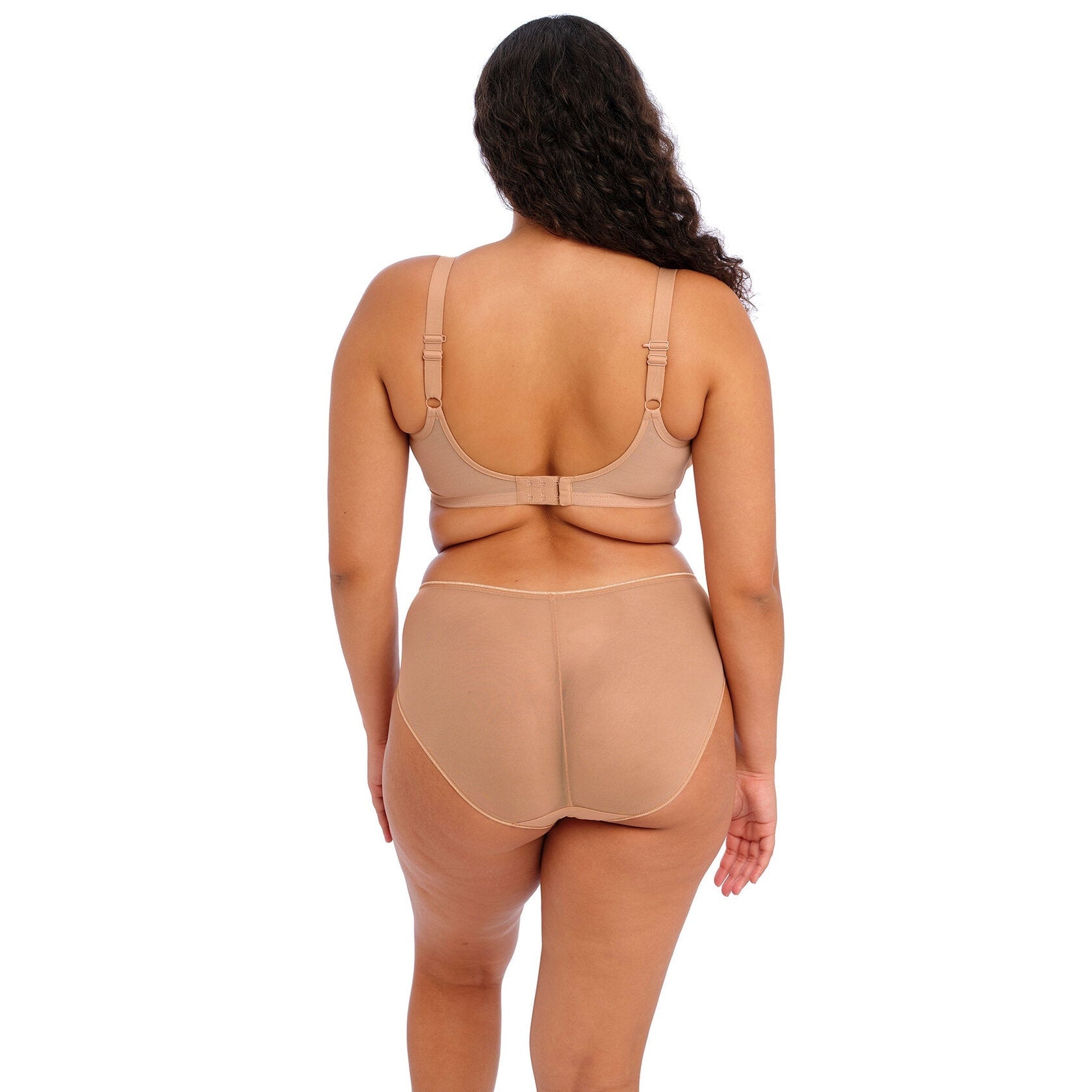 A person wearing a beige bra and panty set against a white background.