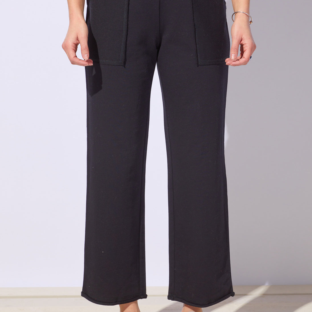 Person wearing black wide-leg pants with a plain background