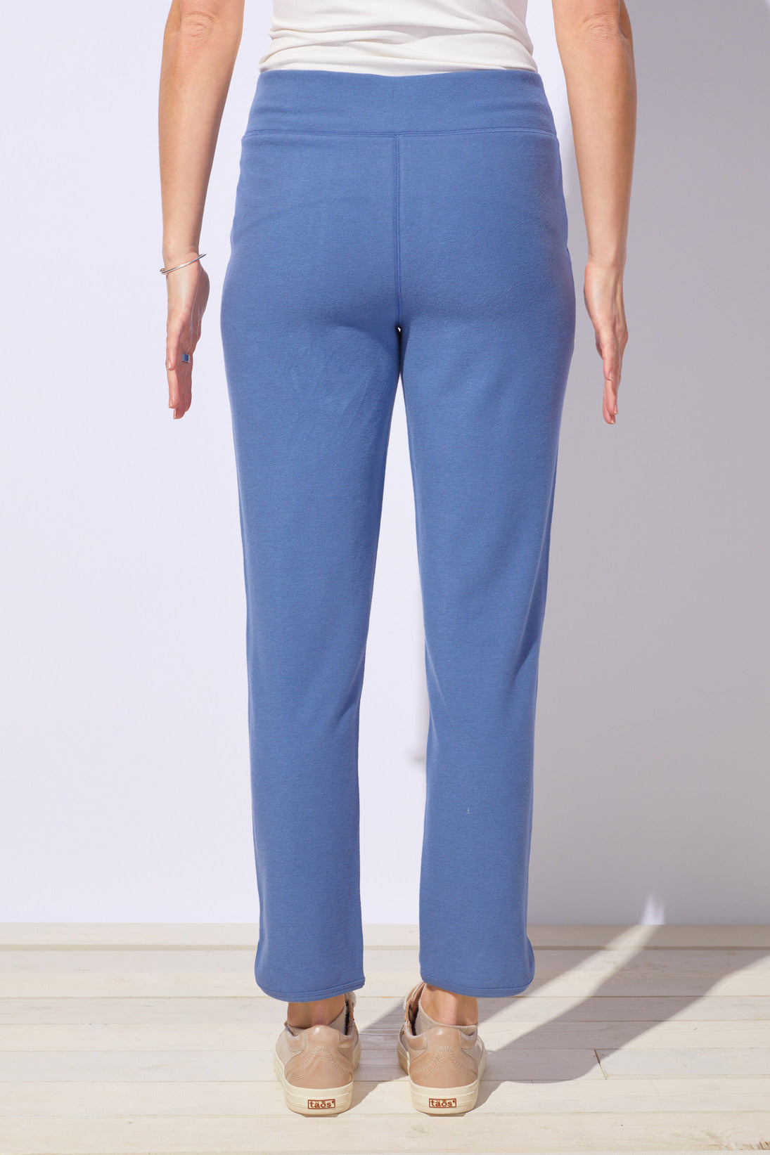 Person wearing blue pants with a plain background