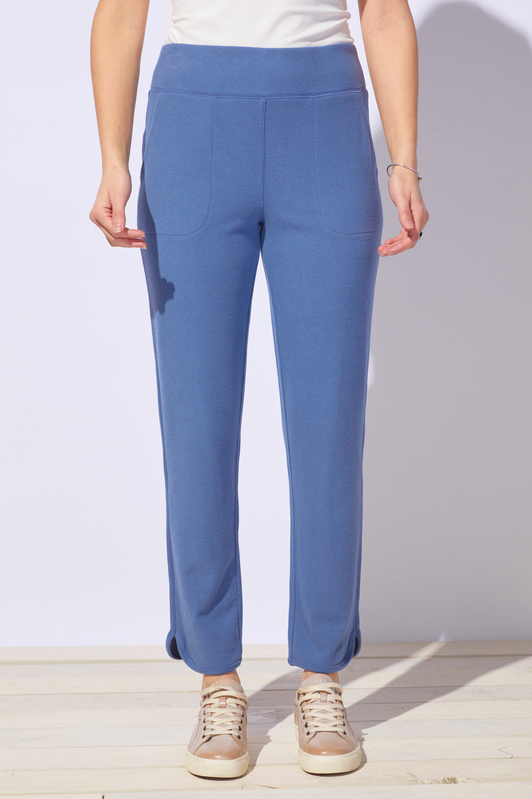 Person wearing blue pants with a plain background