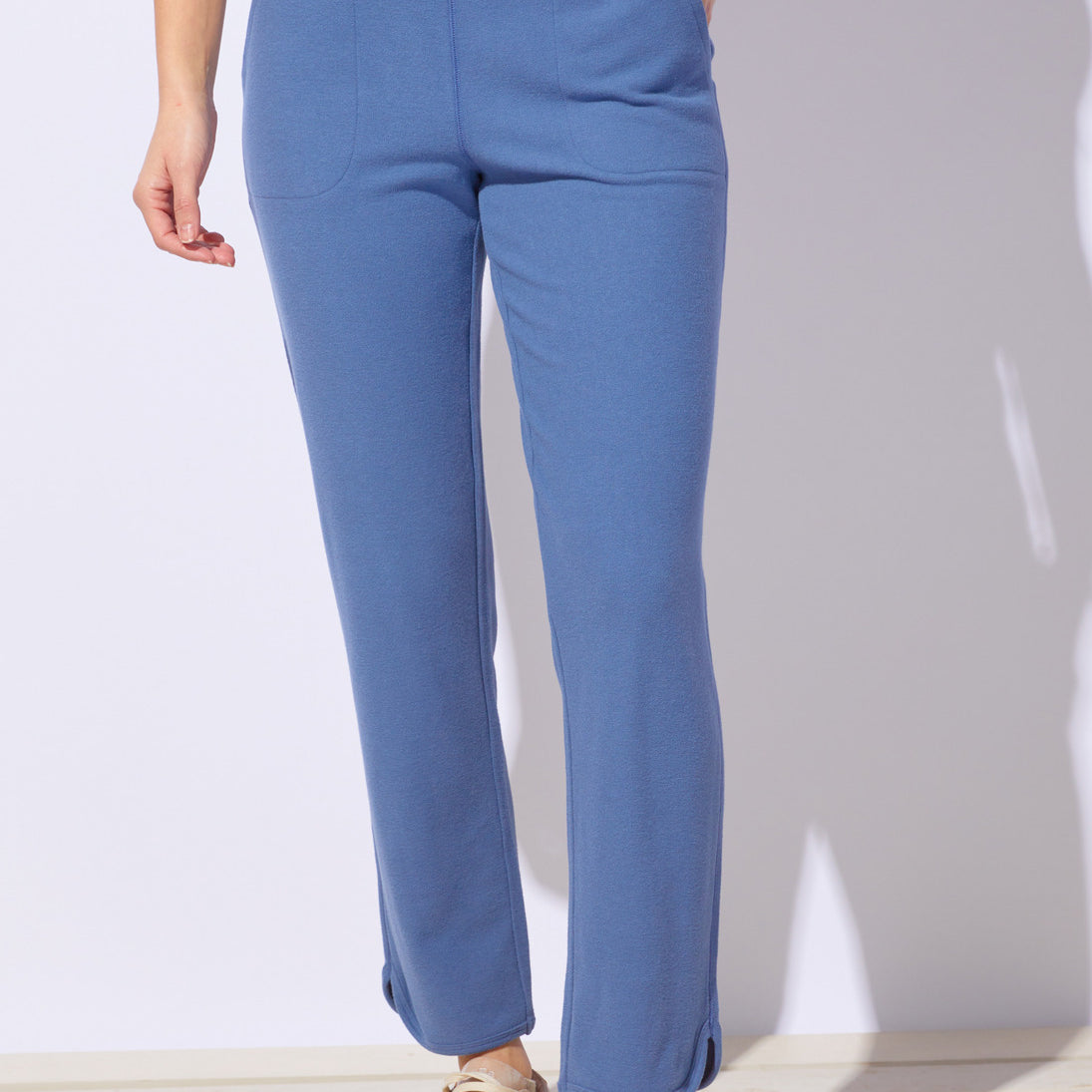 Blue pants worn by a person on a white background