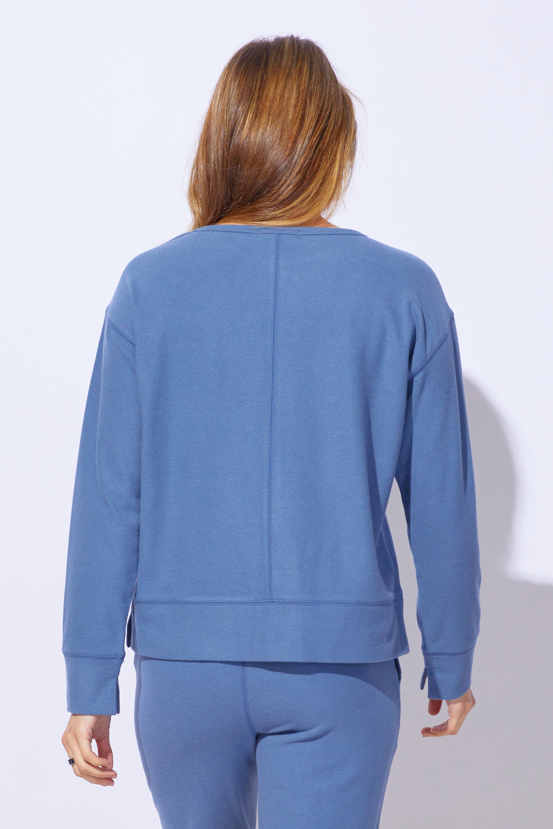Person wearing a blue tracksuit against a white background