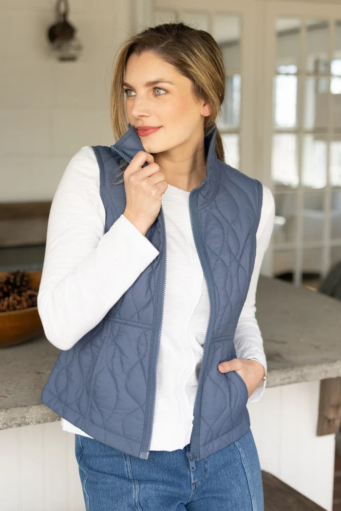Woman wearing a blue quilted vest indoors