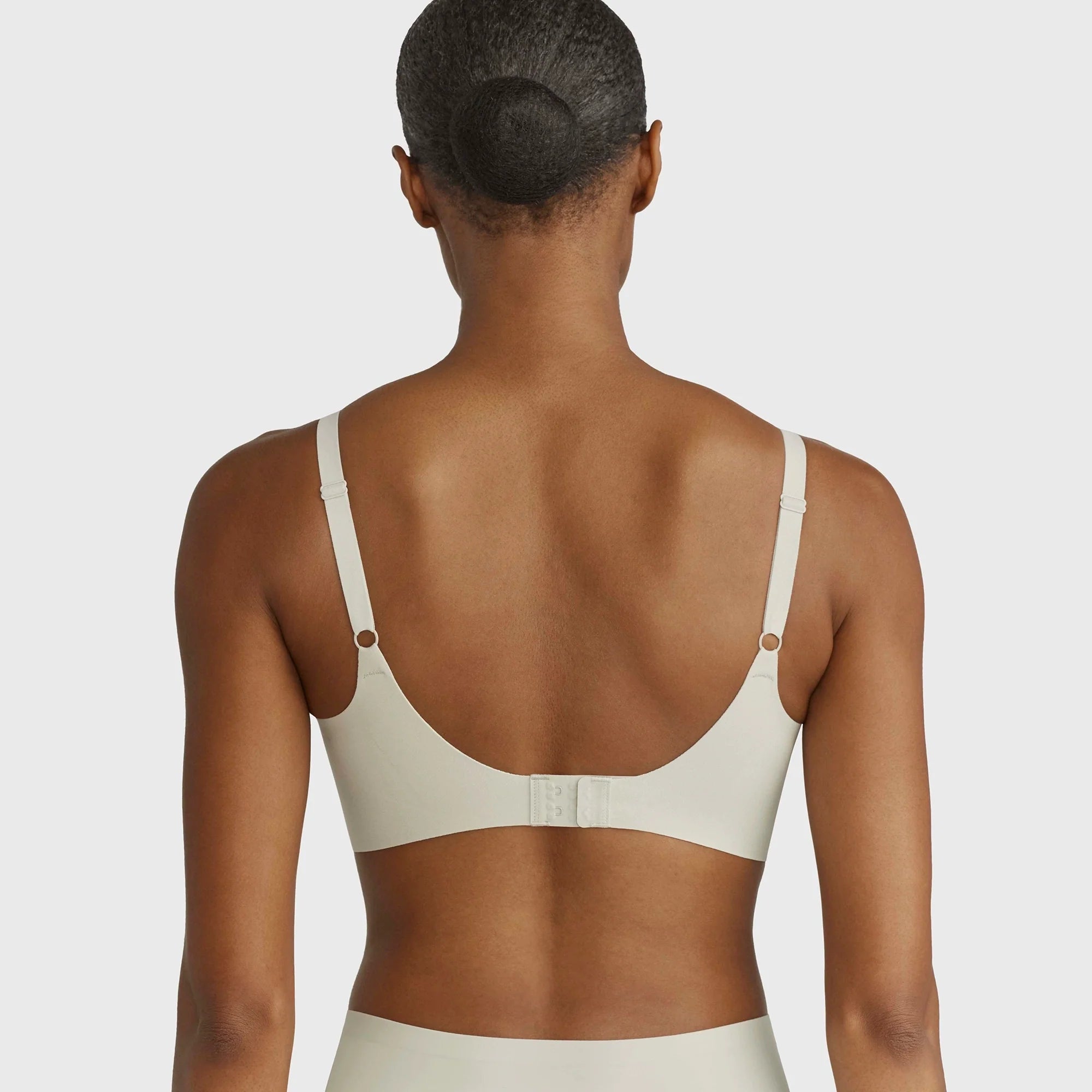 Beyond Bra in Aloe, light green sage wirefree bra on a model showing the back of the bra.