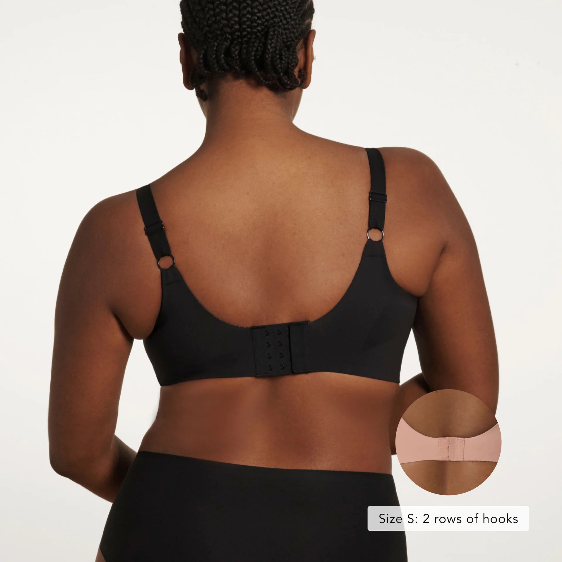 The Beyond Bra in Black, a wirefree bra shown on a model from the back view so you can see the adjustable straps and hook and eye back closure.
