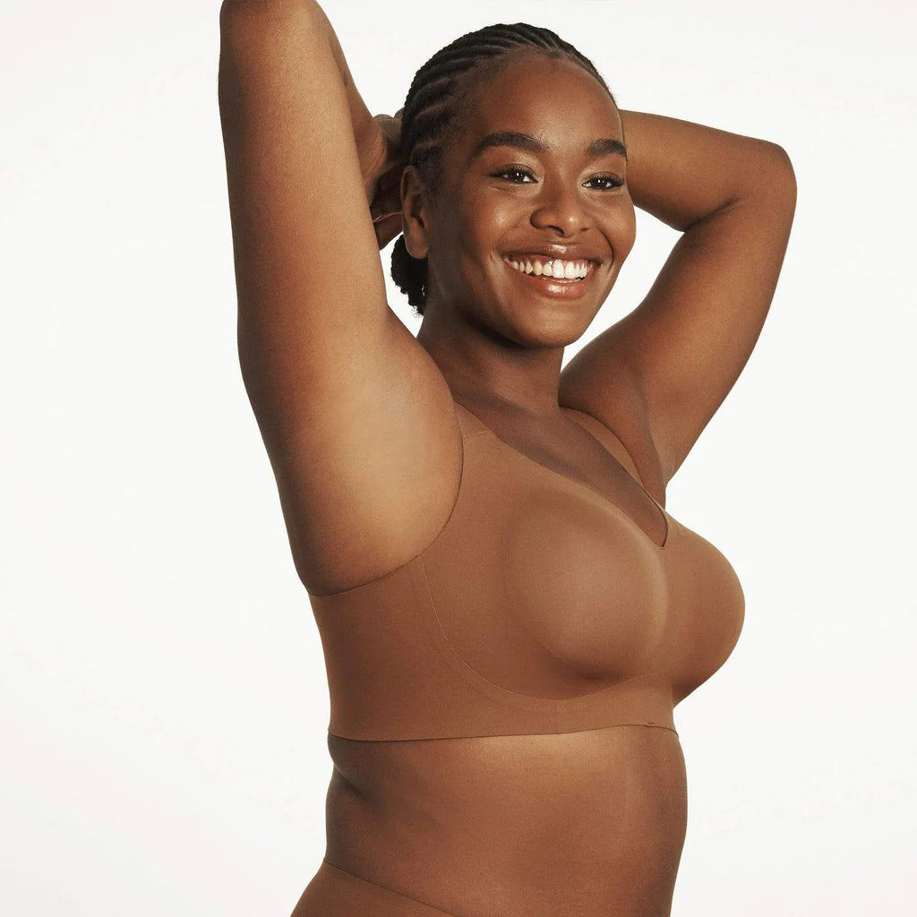 Beyond Bra in Clay, brown wirefree bra shown on a model with her arms up to showcase the fit of the band underneath armpits.