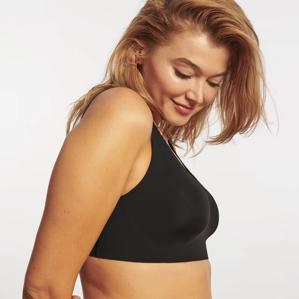 Woman wearing the Evelyn Bobbie Evelyn Bra in Black, no wire pullover bra, against a white background, side view.