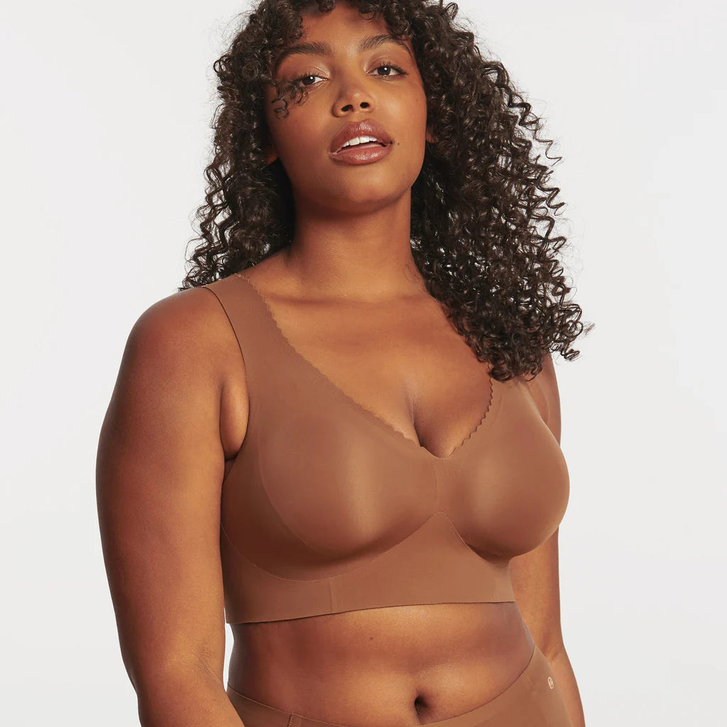 Woman wearing the Evelyn & Bobbie Evelyn Bra in Clay, brown no wire pullover bra, against a white background, front view.