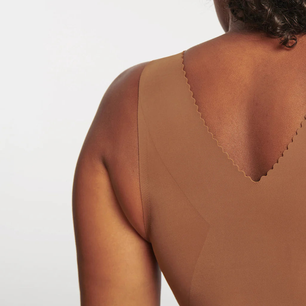 Woman wearing the Evelyn & Bobbie Evelyn Bra in Clay, brown no wire pullover bra, against a white background, close up back view.
