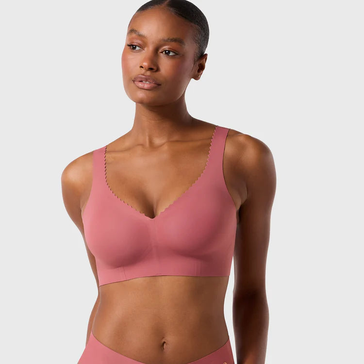 Woman wearing the Evelyn & Bobbie Evelyn Bra in Pink Canyon, dusty pink no wire pullover bra, on a white background, front view.