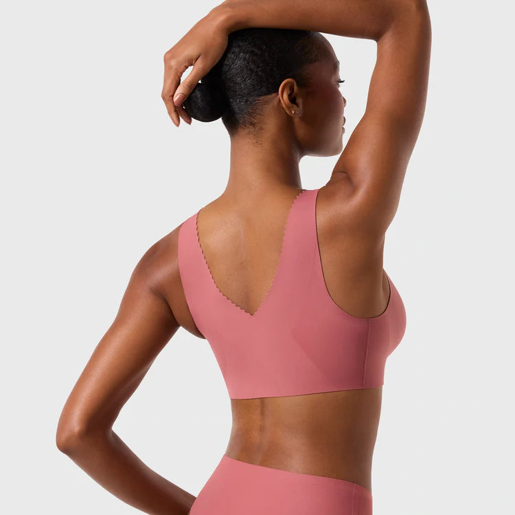 Woman wearing the Evelyn & Bobbie Evelyn Bra in Pink Canyon, dusty pink no wire pullover bra, on a white background, back view.
