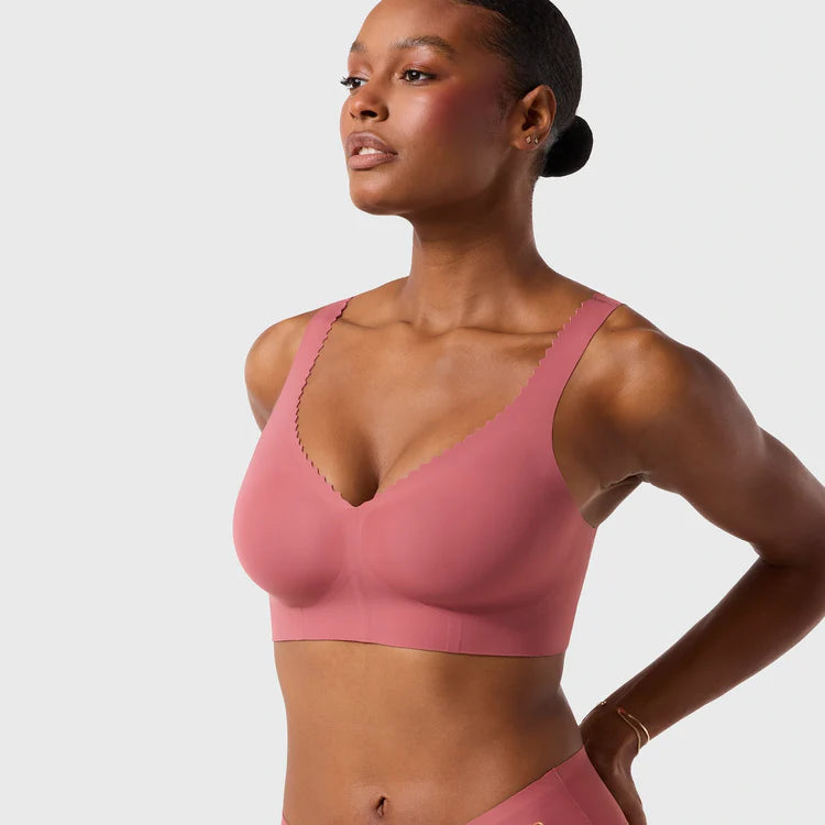 Woman wearing the Evelyn & Bobbie Evelyn Bra in Pink Canyon, dusty pink no wire pullover bra, on a white background, front view.