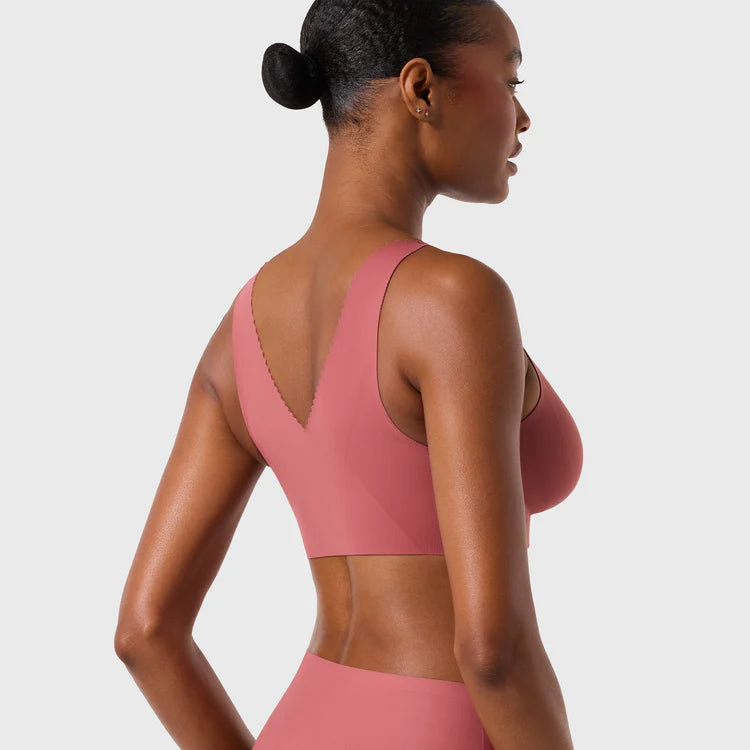 Woman wearing the Evelyn & Bobbie Evelyn Bra in Pink Canyon, dusty pink no wire pullover bra, on a white background, back view.