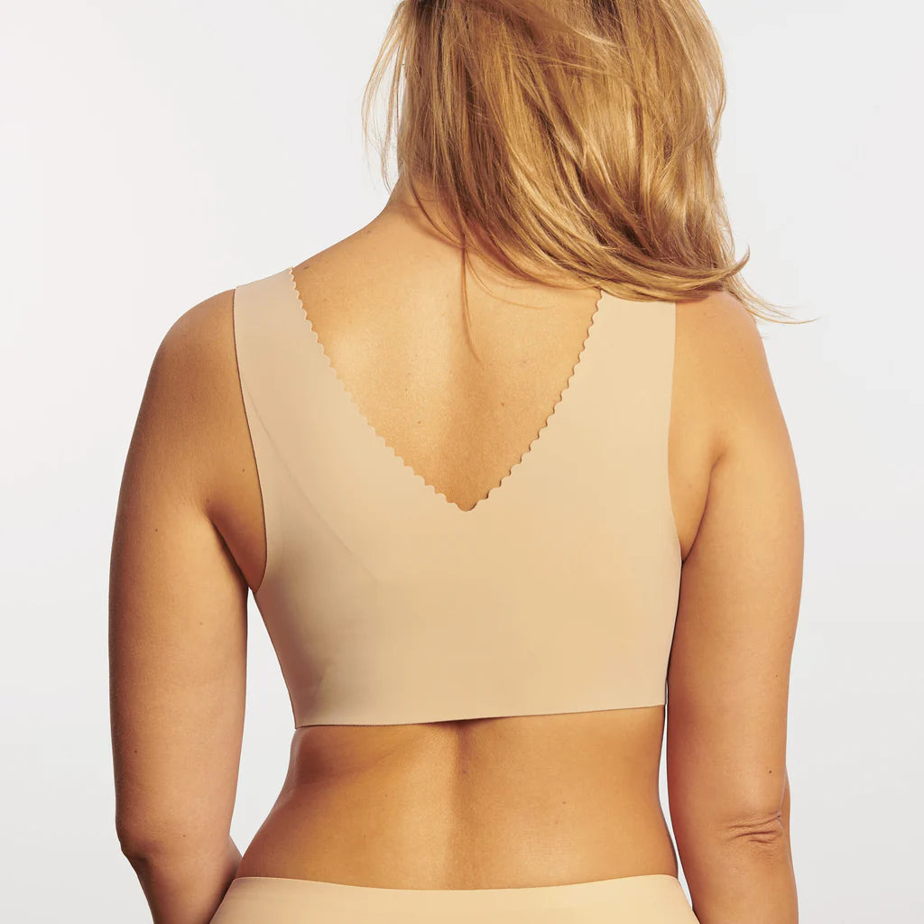 Woman wearing the Evelyn & Bobbie Evelyn Bra in Sand, beige no wire pullover bra with scalloped edges, on a white background, back view.