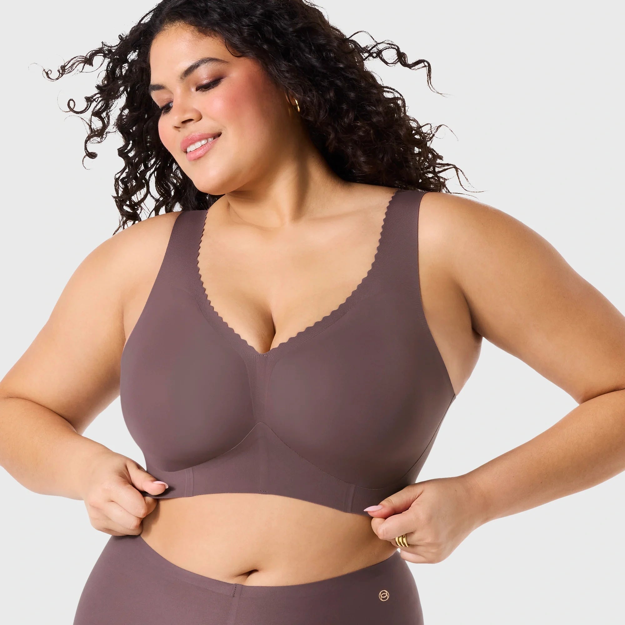 Woman wearing Evelyn & Bobbie Evelyn Bra in Thistle, dark mauve no wire pullover bra, against a white background, front view.
