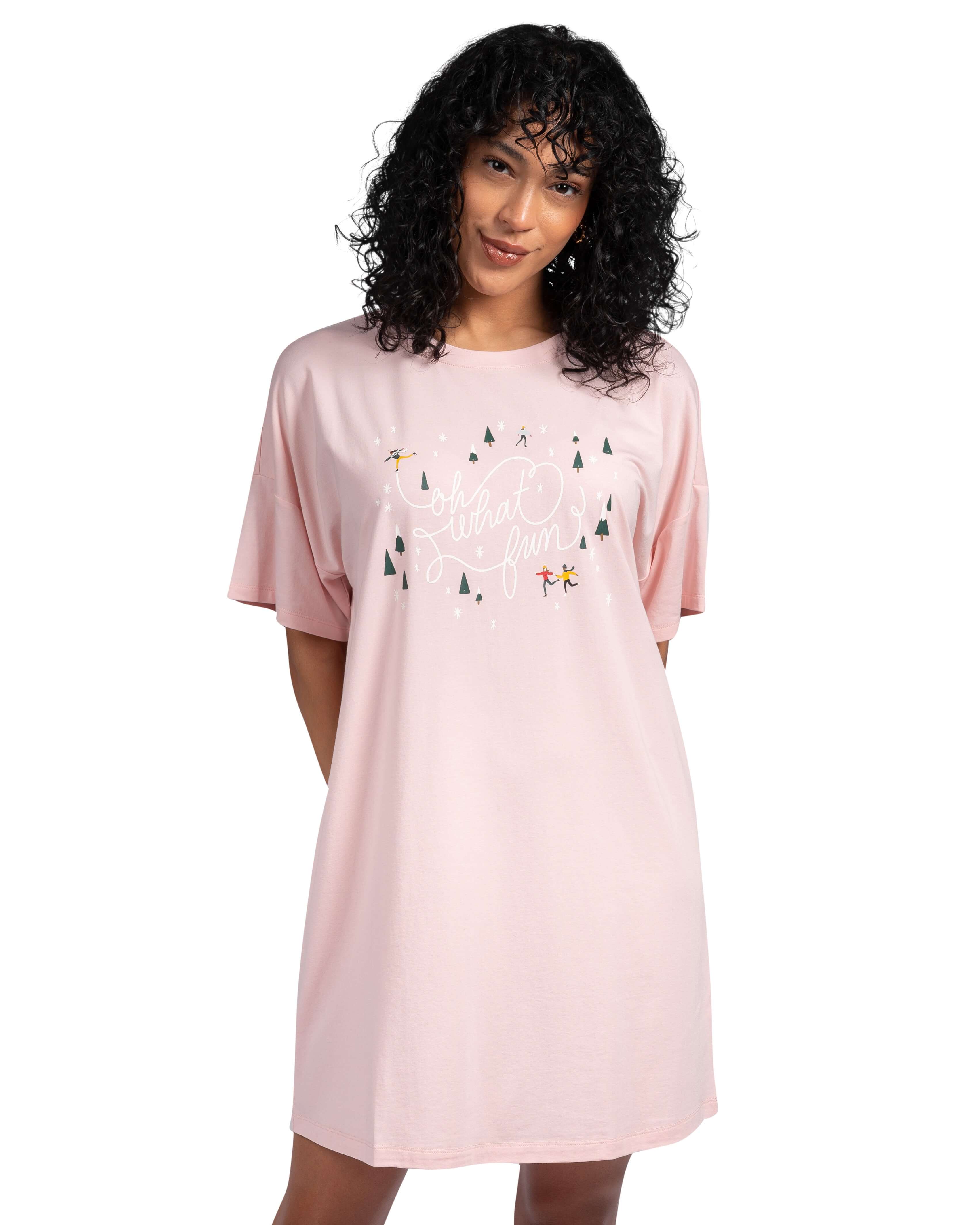 Woman wearing a pink nightshirt with tree design on a white background