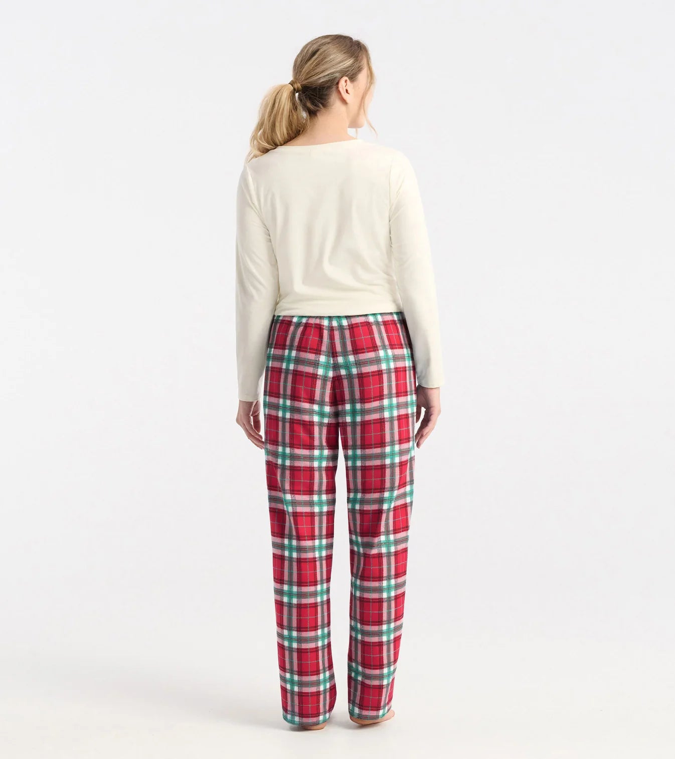 Person wearing red plaid pants and a white top on a white background