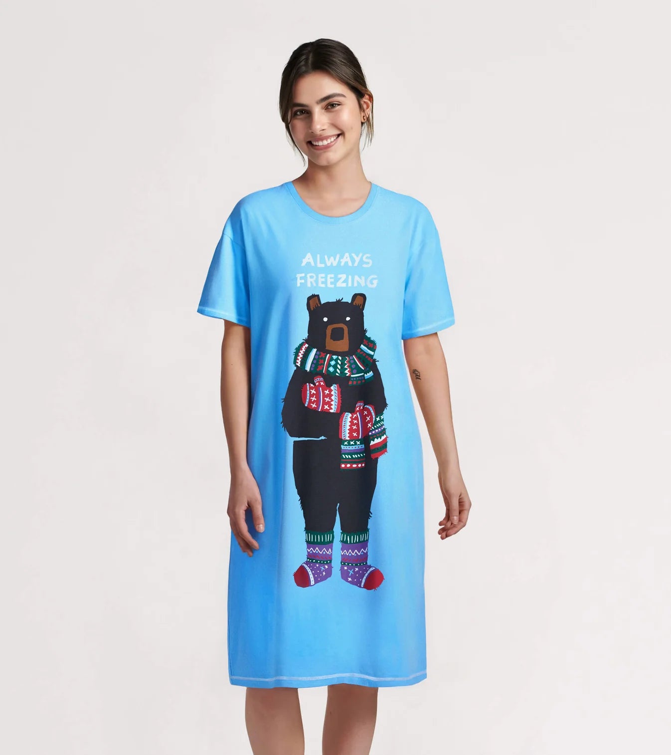 Woman wearing a blue nightshirt with a bear graphic and text on a white background