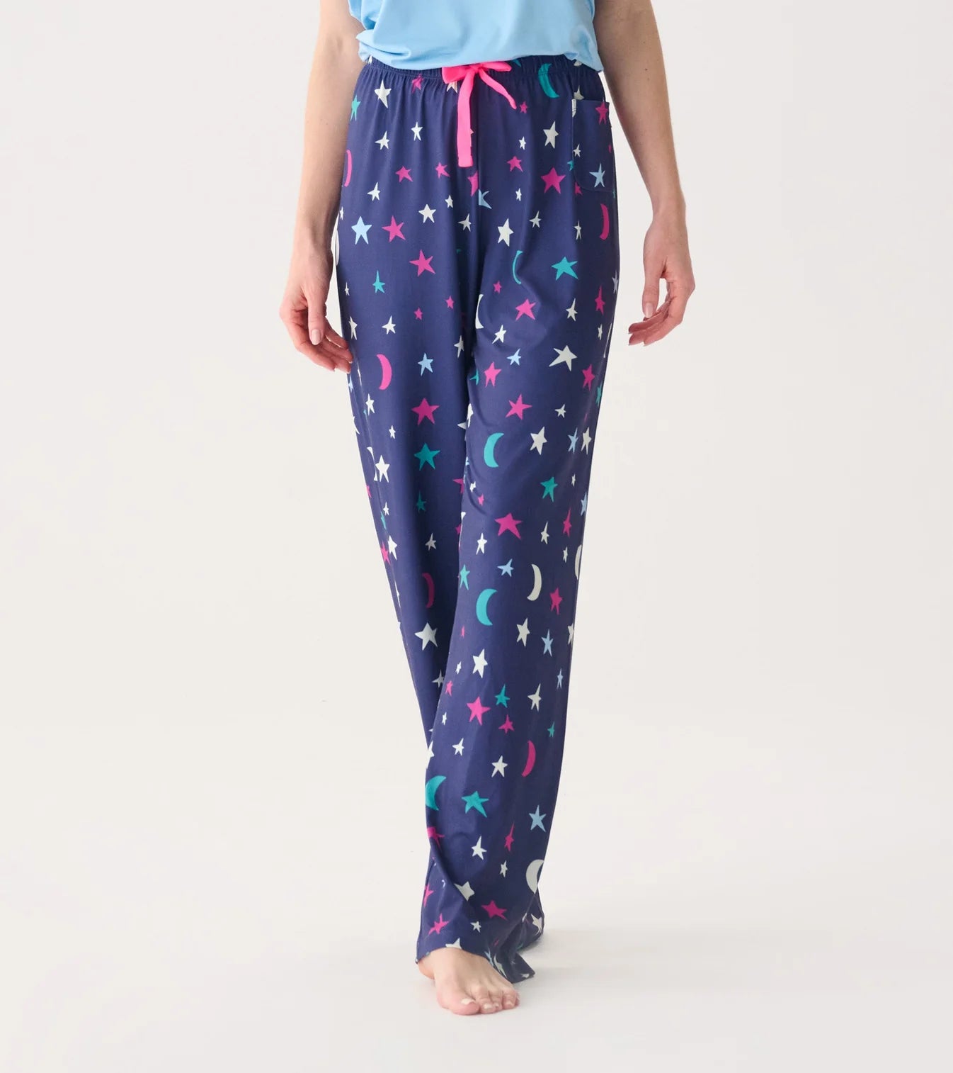 Navy blue pajama pants with star and moon pattern worn by a person on a white background