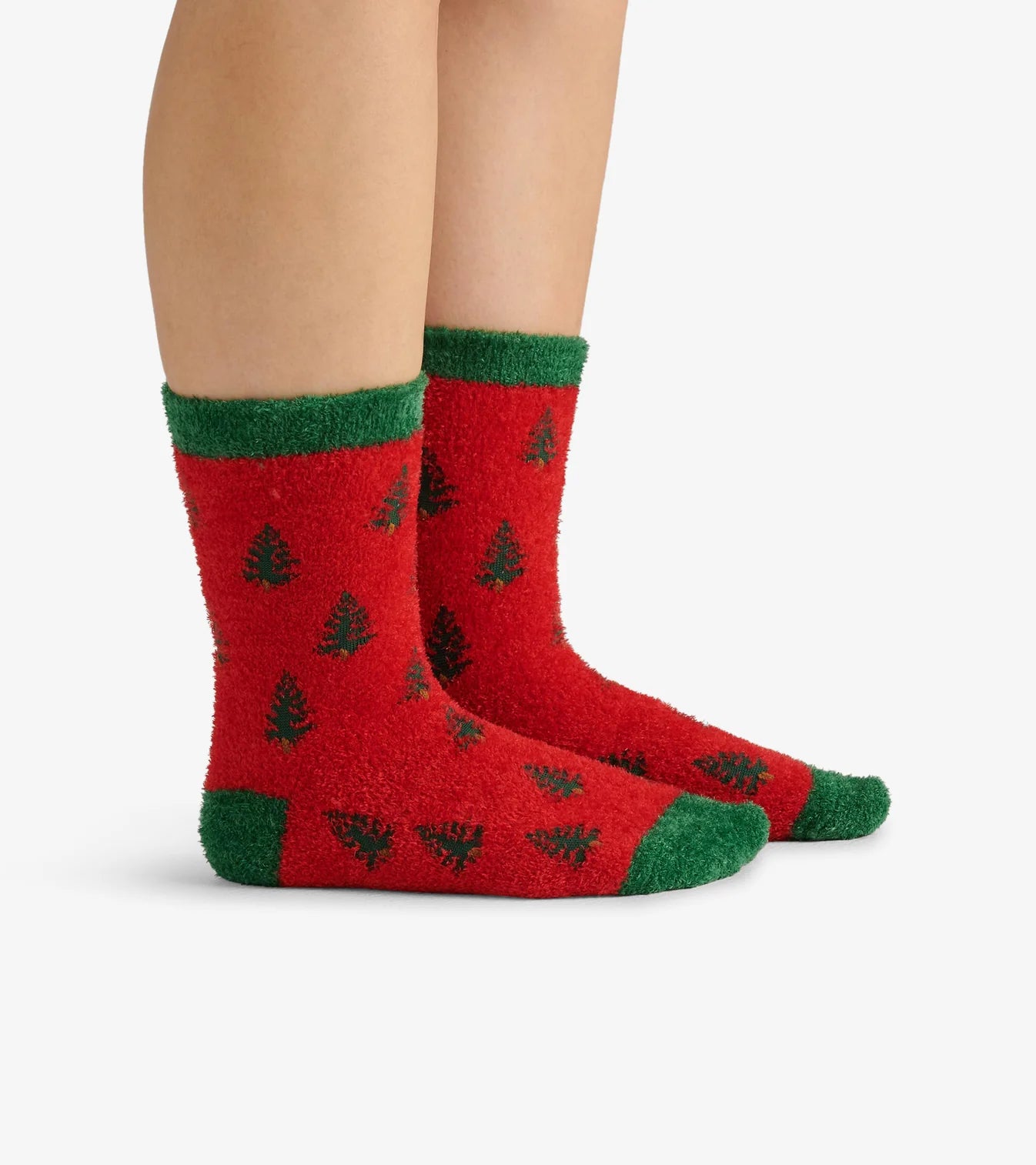 Red socks with green accents and tree patterns worn by a person on a white background