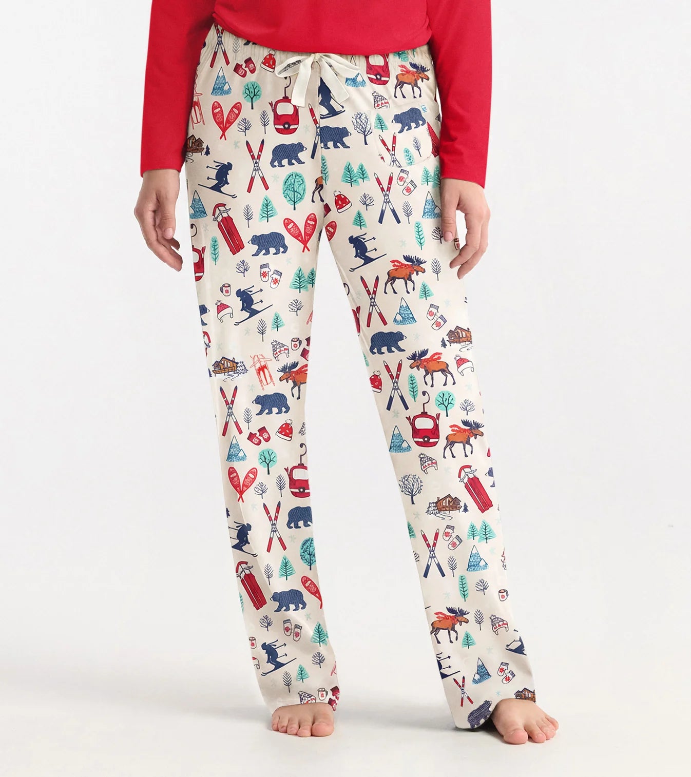 Person wearing patterned pajama pants with a red top on a white background