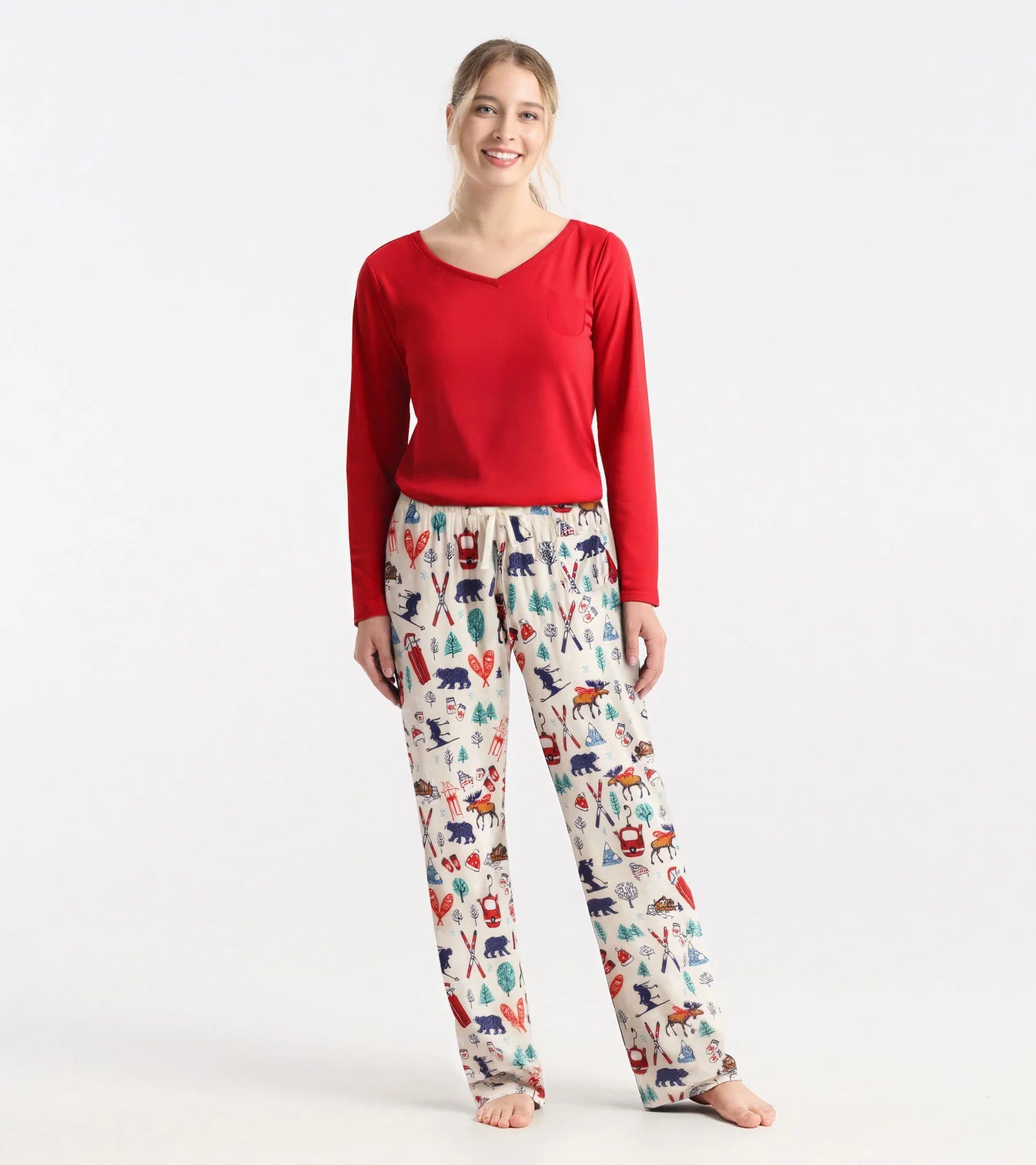 Woman wearing a red top and patterned pajama pants on a white background