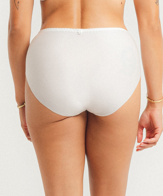 White underwear worn by a person on a plain background