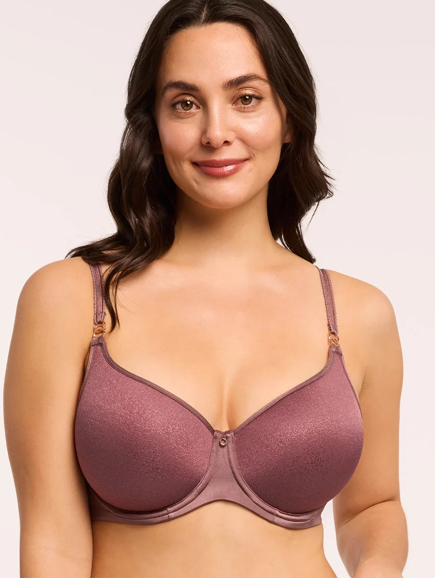 Woman wearing a purple bra against a plain background