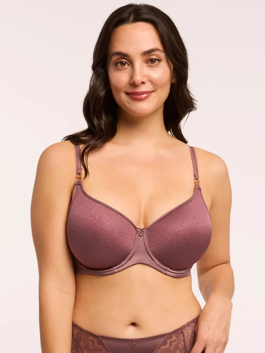 Woman wearing a purple bra and underwear set on a plain background