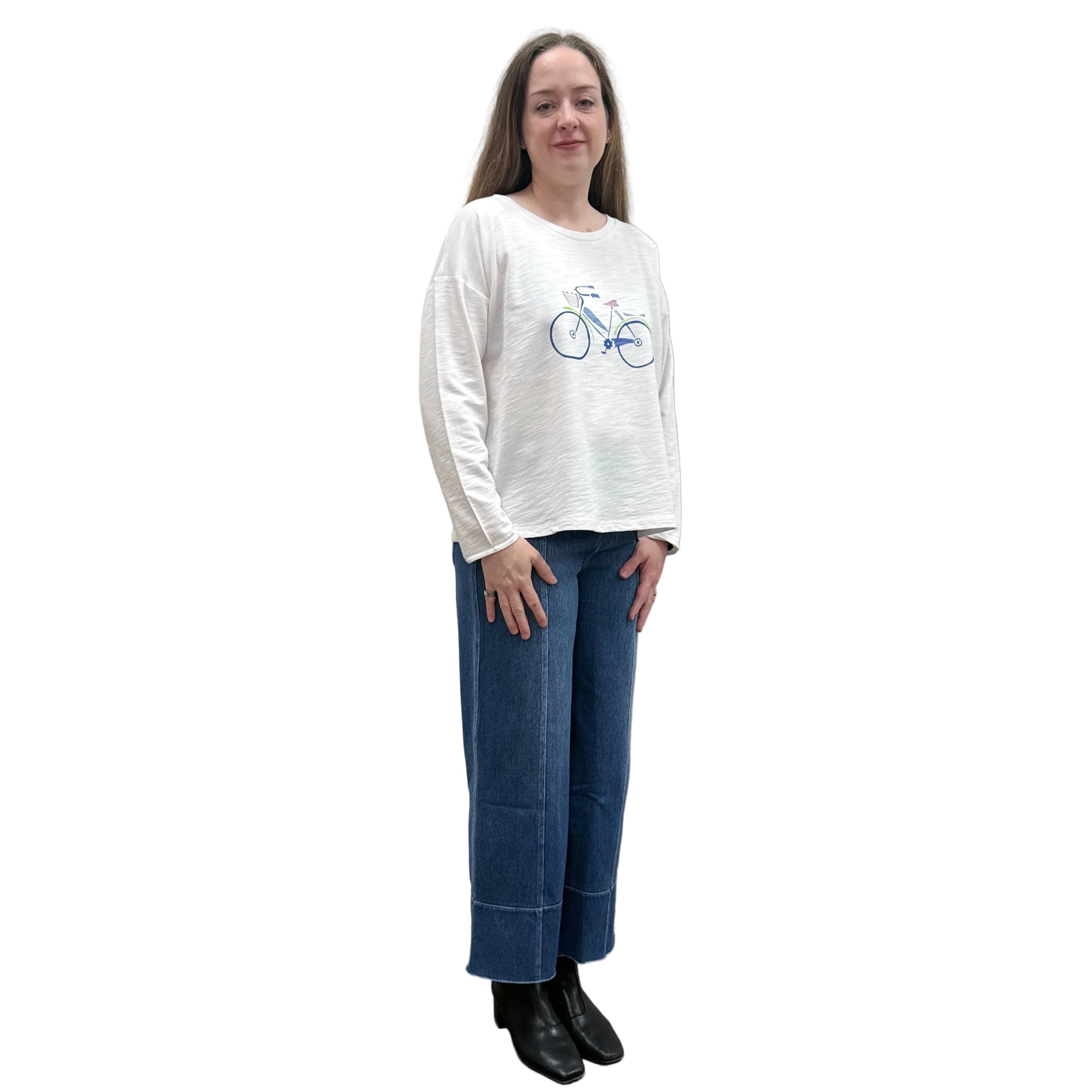 Person wearing a white long-sleeve Papa Bicycle Pullover shirt and blue jeans standing on a white background.