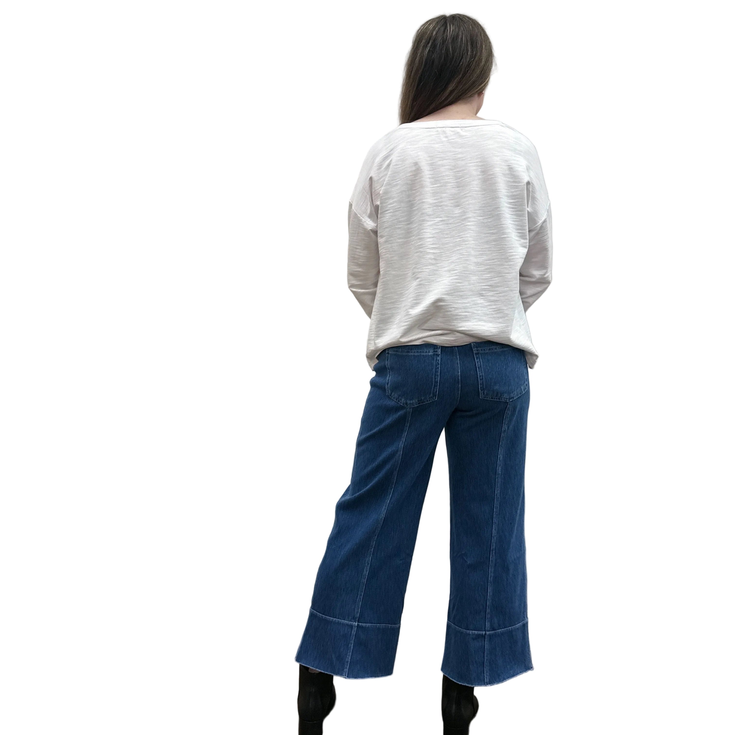 Person wearing a white long-sleeve Papa Bicycle Pullover shirt and blue jeans standing on a white background.
