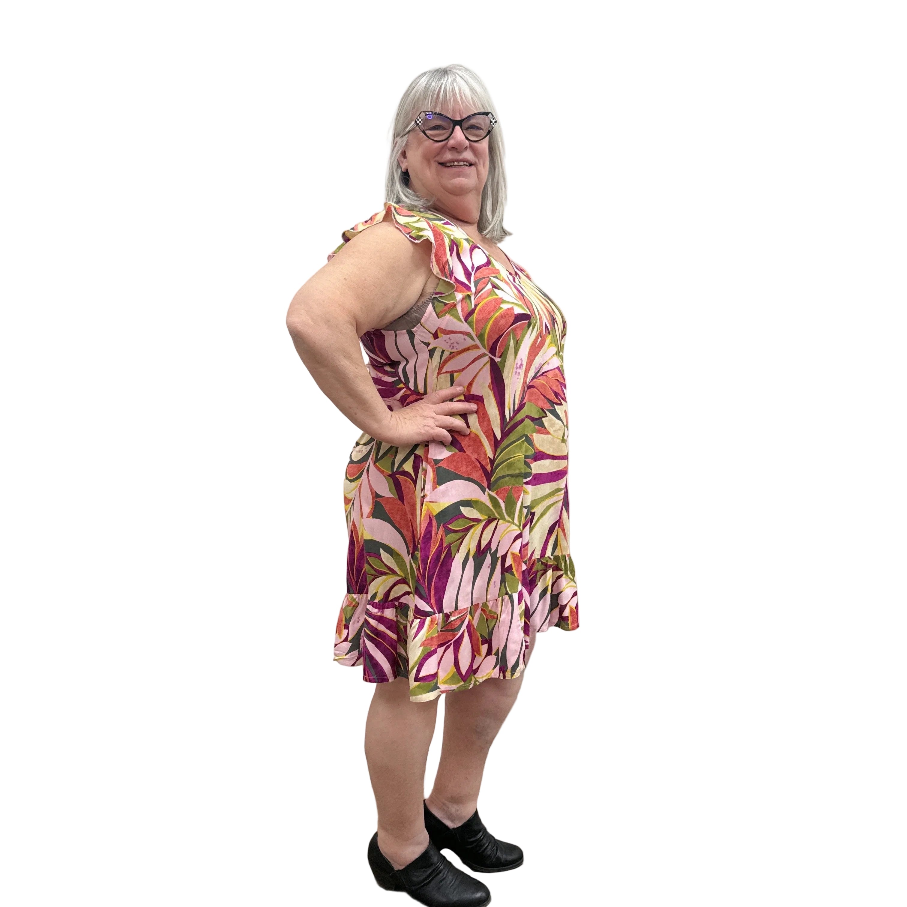 Woman wearing a colorful floral Papa Classic Print dress in Pink against a plain wall.