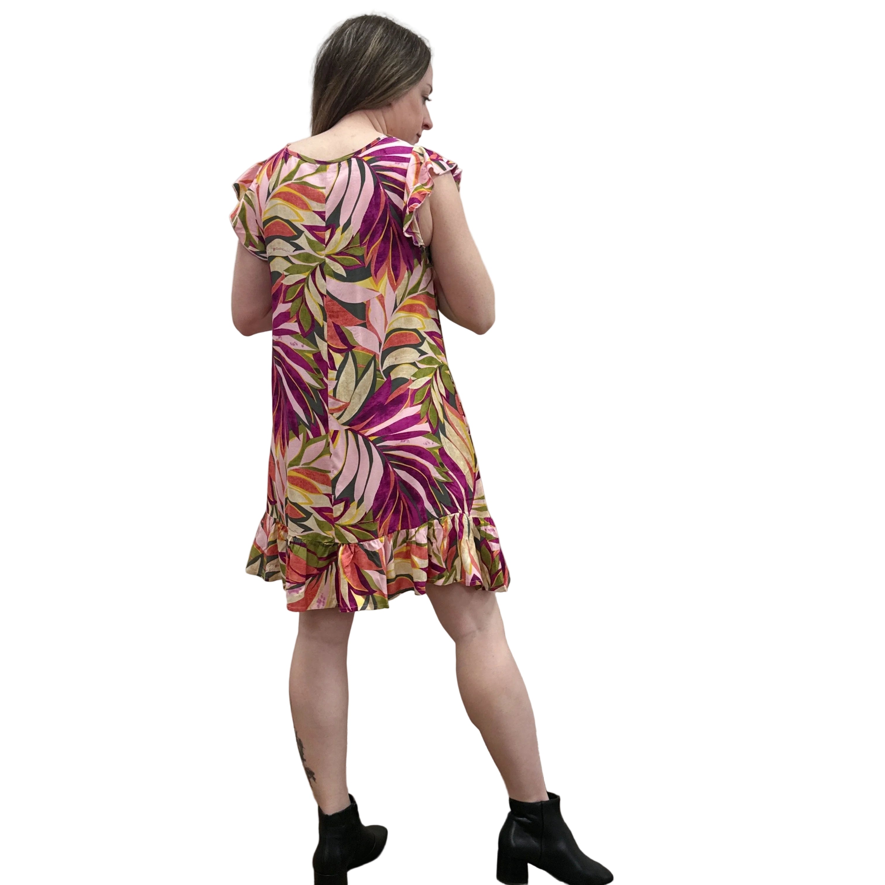 Woman wearing a colorful floral Papa Classic Print dress in Pink against a plain wall.