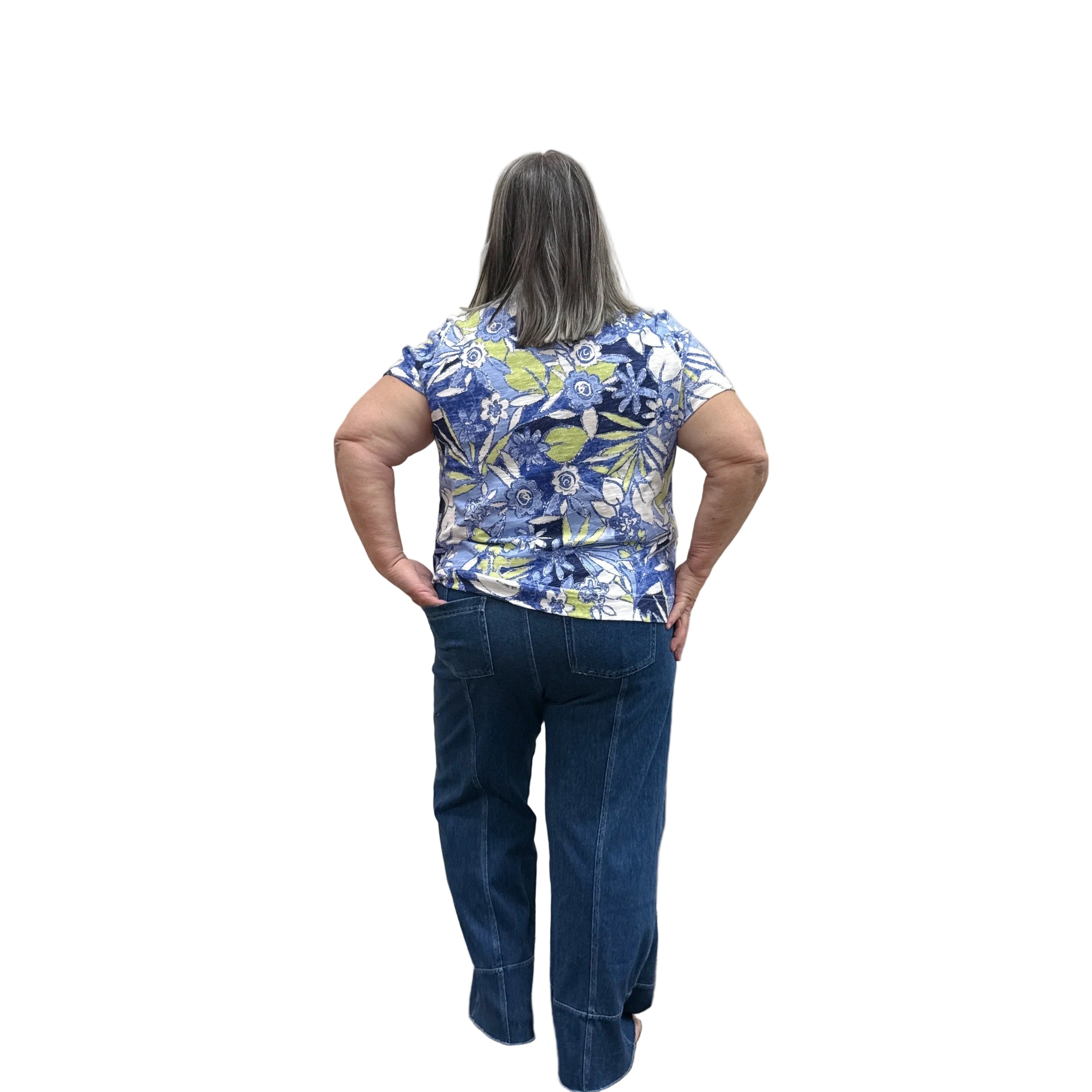 Person wearing a blue floral top and blue Papa Comfort Crop jeans standing against a plain wall, back view.