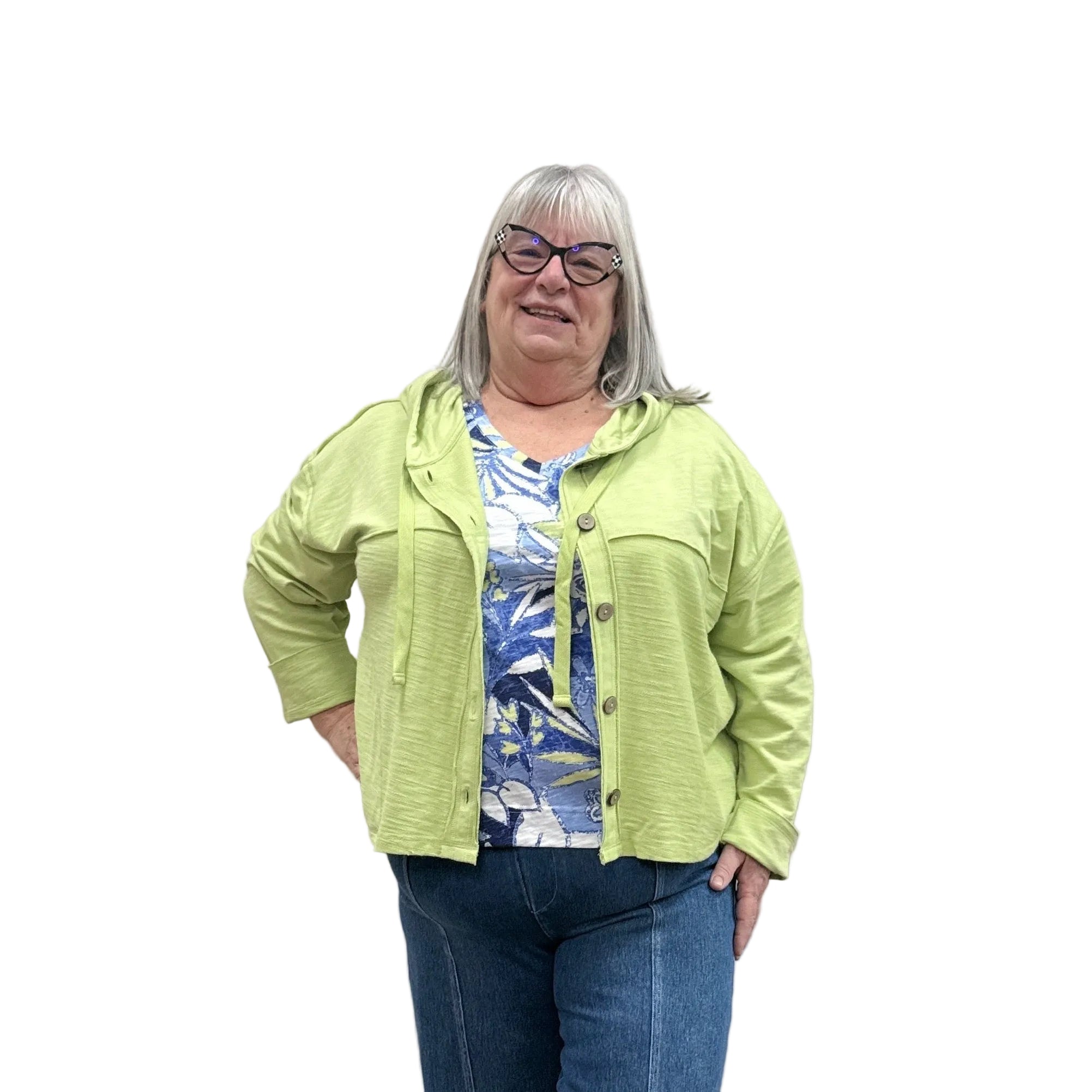 Person wearing a kiwi green Cruising Hoodie jacket and blue pants standing against a plain wall.