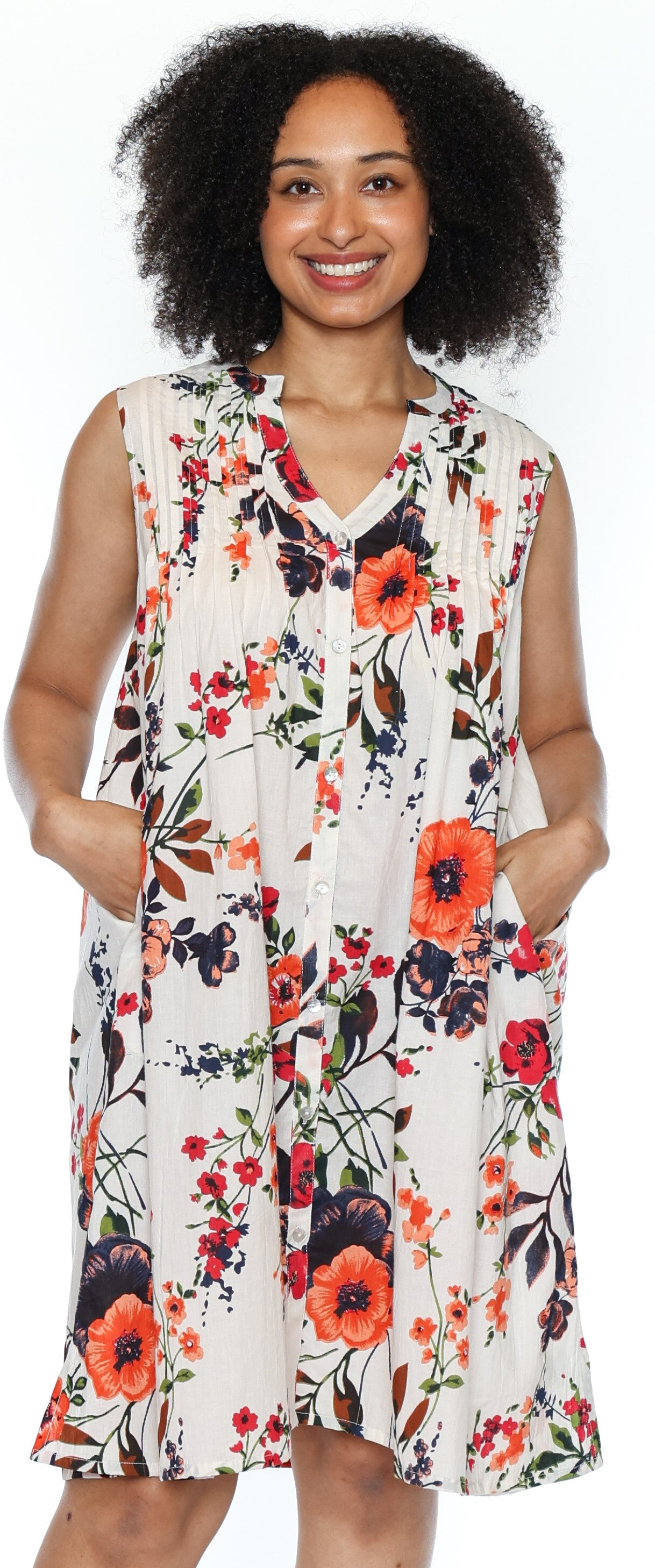 Woman wearing a sleeveless floral dress with orange flowers on a white background