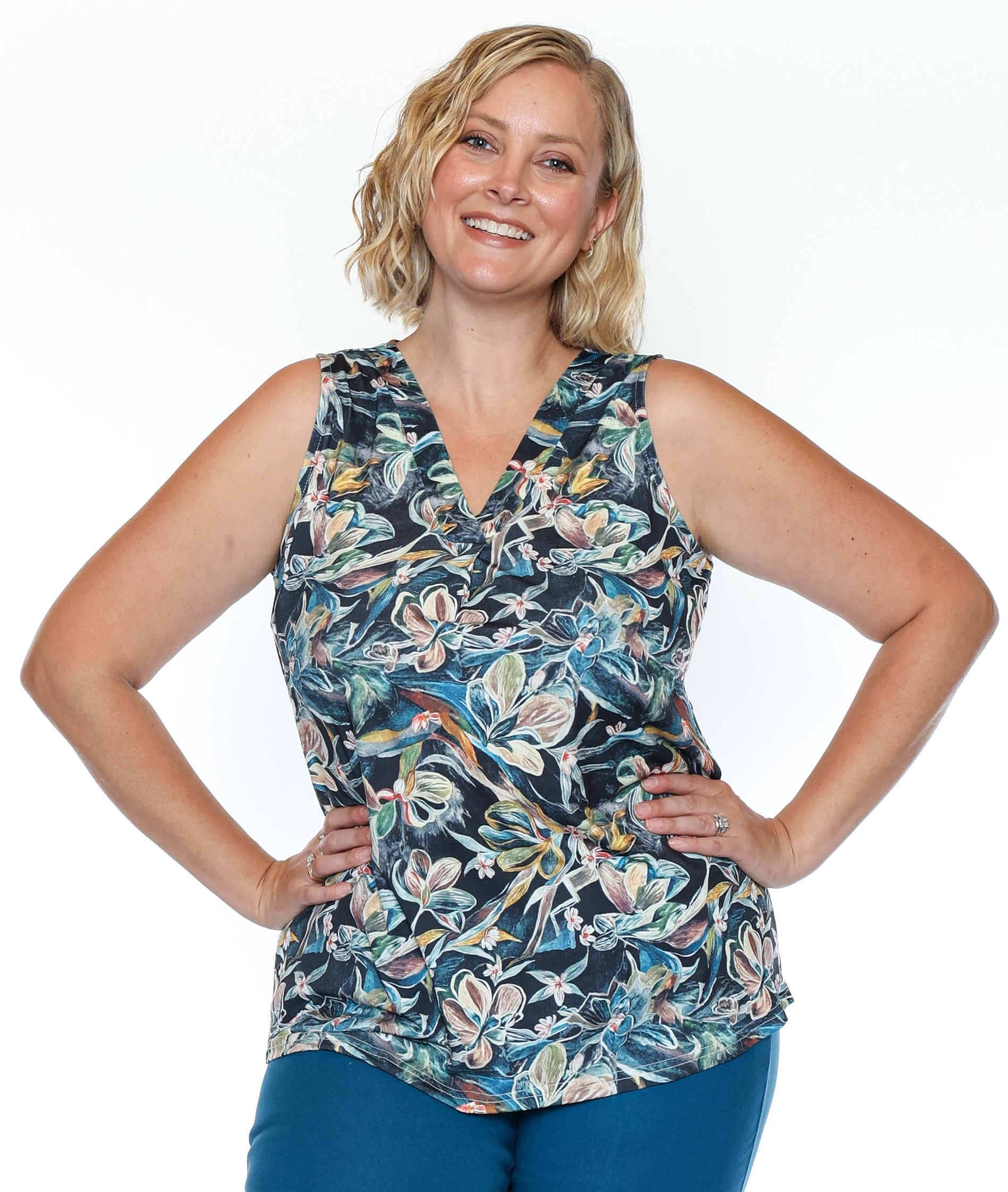 Woman wearing a sleeveless floral top on a white background