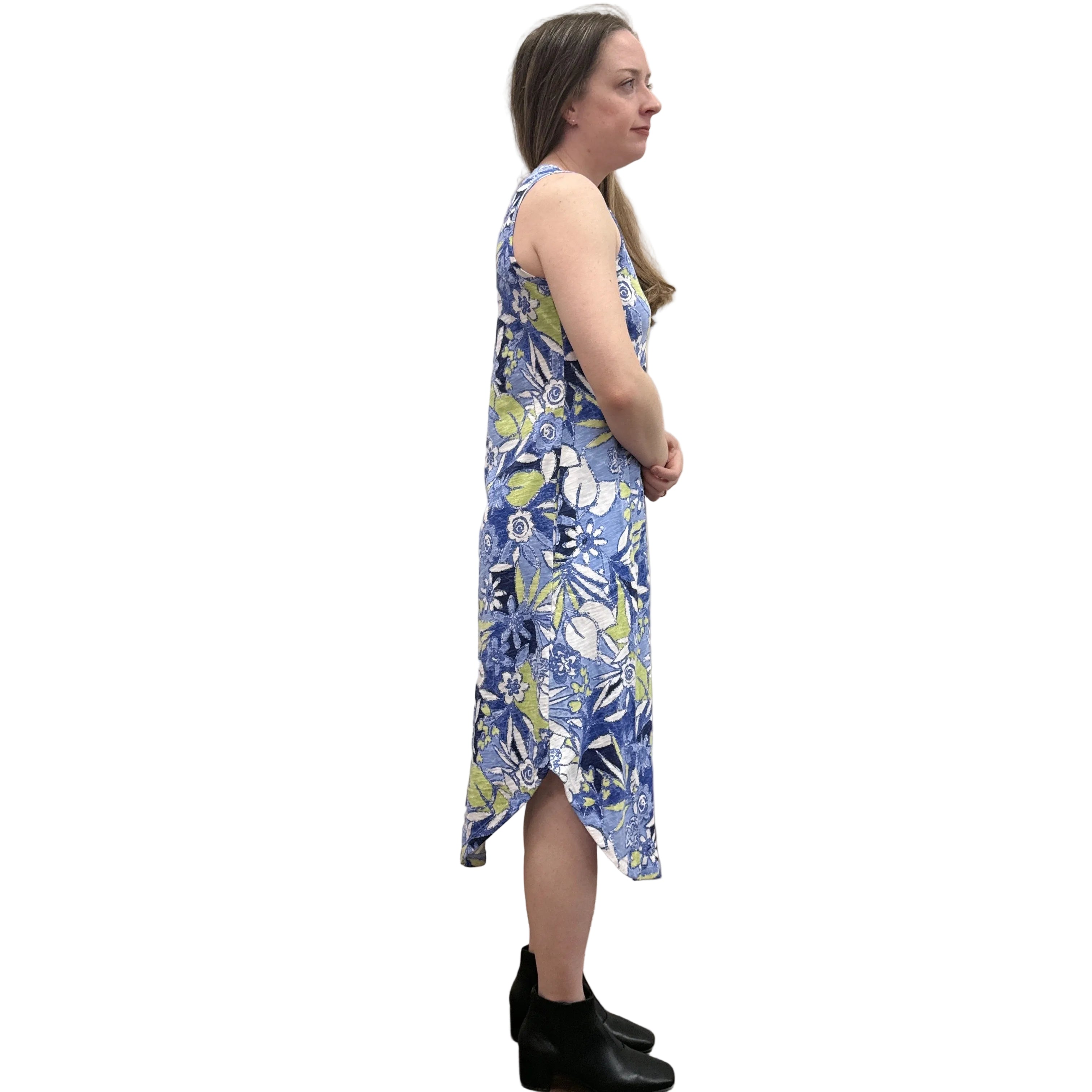 Woman wearing a blue floral Papa Seamed Sleeveless dress standing against a plain wall.