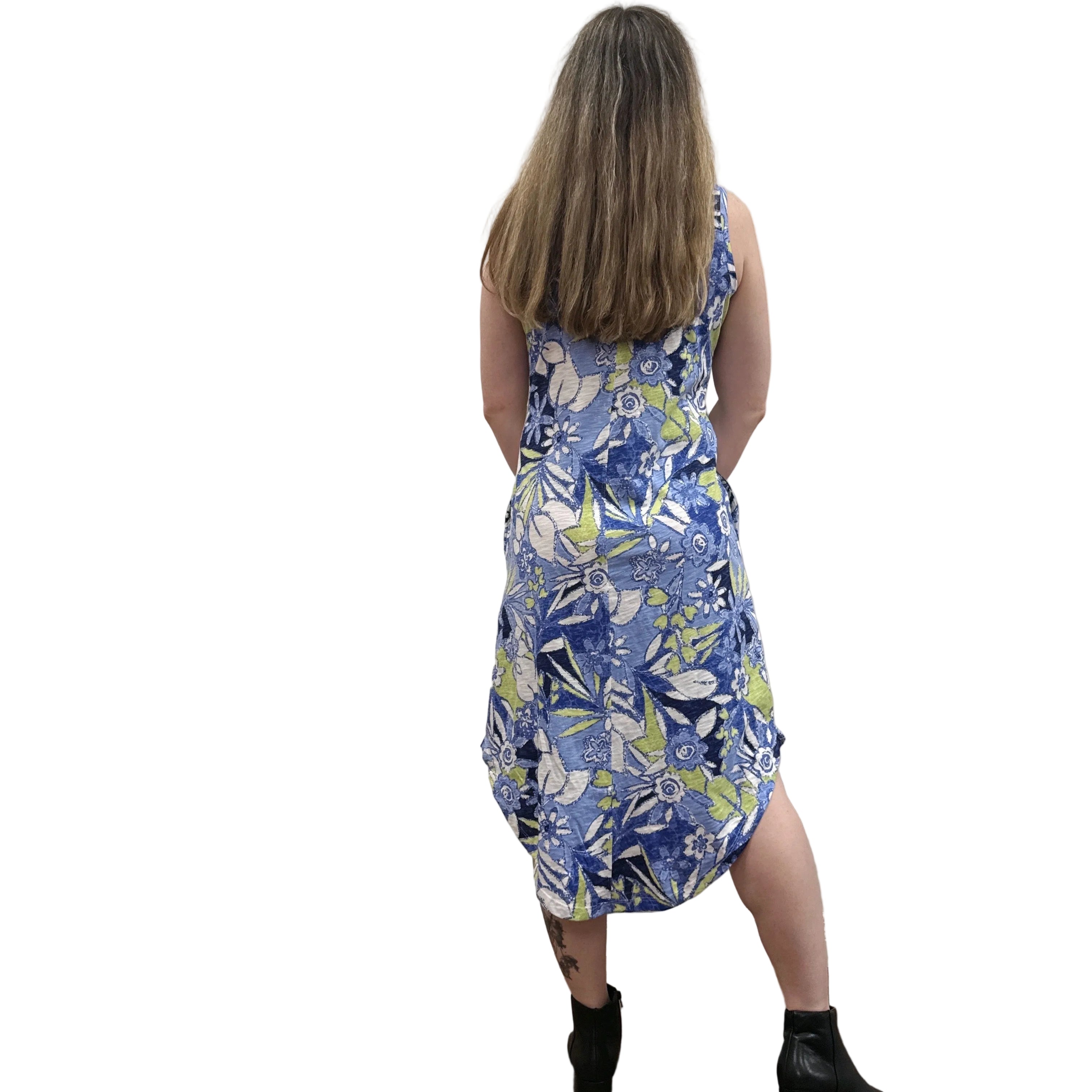 Woman wearing a blue floral Papa Seamed Sleeveless dress standing against a plain wall.