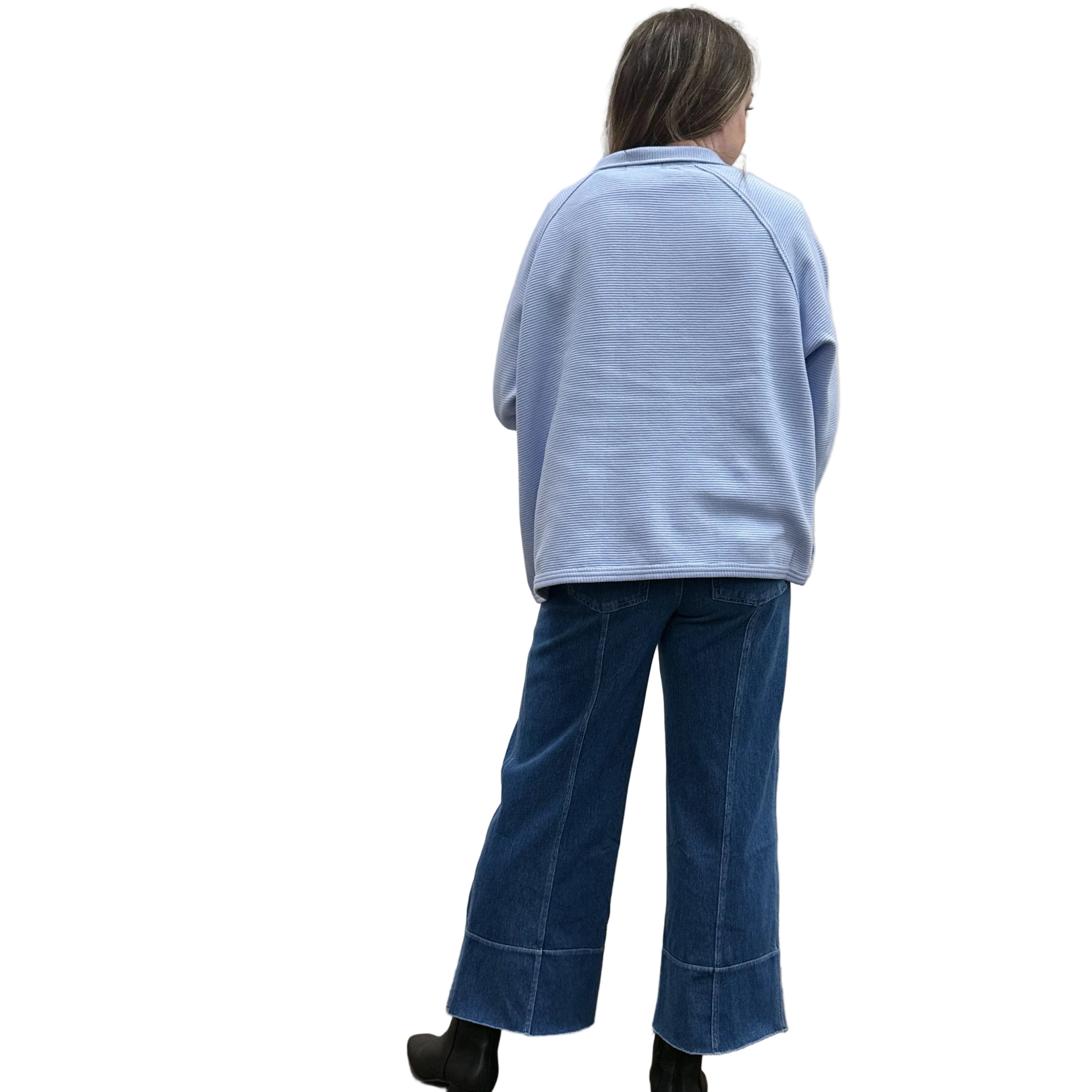 Person wearing a blue Papa Snappy Jacket sweater and jeans on a white background.