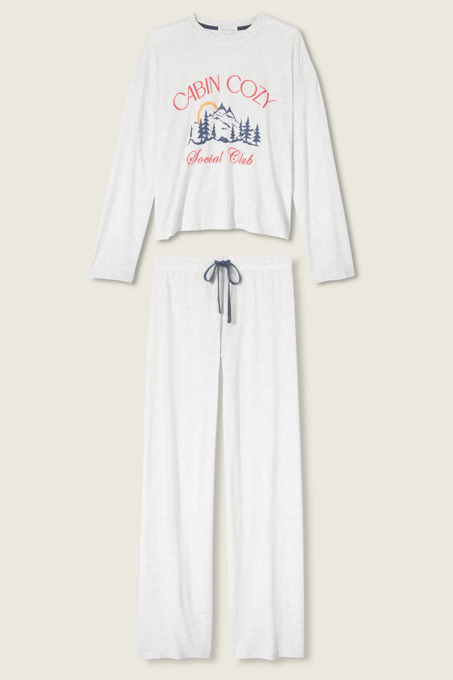 White long-sleeve pajama set with 'Cabin Cozy' graphic on a beige background