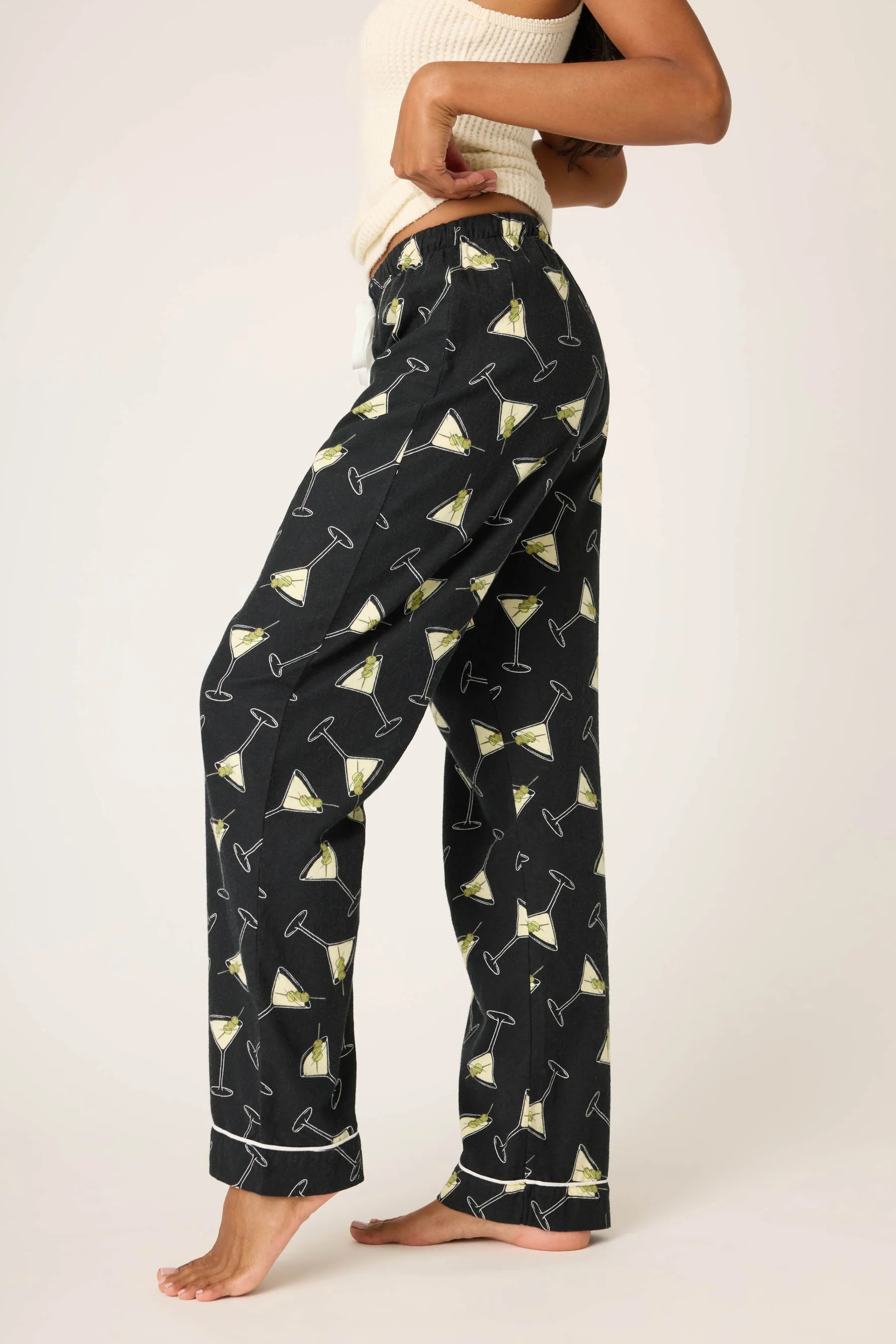 Person wearing black pajama pants with cocktail print on a white background