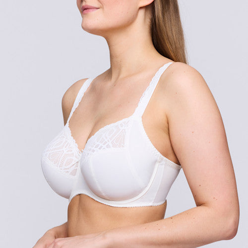 Woman wearing a white bra against a plain background