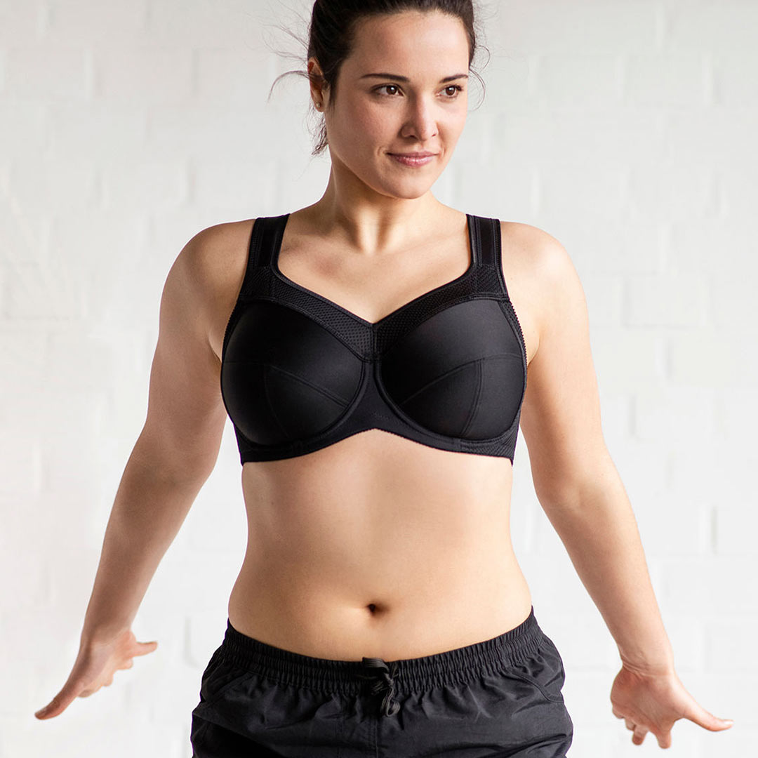 A woman wearing a black sports bra, which appears to be the product in question.