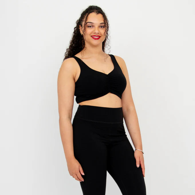 Blue Sky Clipper Top in Black shown on a model against a white background, worn with black leggings.